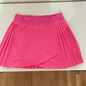 This hot pink tennis skirt is a small and the brand is KYODAN.